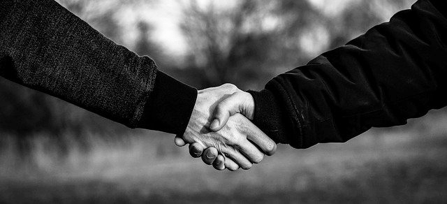 A black and white photo of a handshake